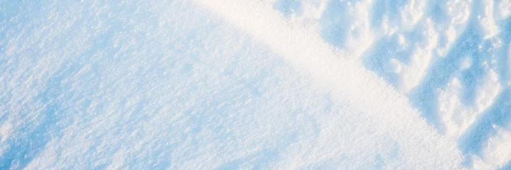 Beautiful winter background with snowy ground. Natural snow texture. Wind sculpted patterns on snow surface. Wide panoramic texture for background and design. © Andrei Stepanov