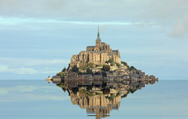 Reflected on the water at high tide of the Hill with the ancient abbey of Mont Saint Michel in...