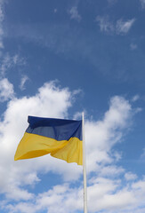 waving flag of Ukraine with yellow and blue colors and sky with some clouds