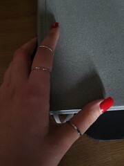 hand with red nails holding a pen