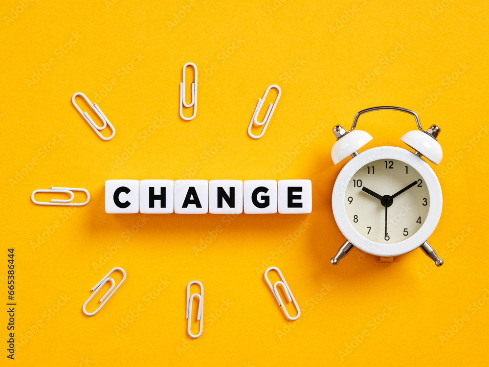 Poster the word change on cubes with alarm clock and paper clips. time for change.