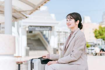出張・旅行でバス停・タクシー乗り場・待合所にいる女性（電話・待ち合わせ）
