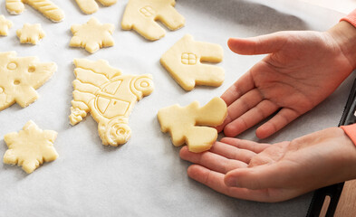 Children's hands with gingerbread cookies on wooden background