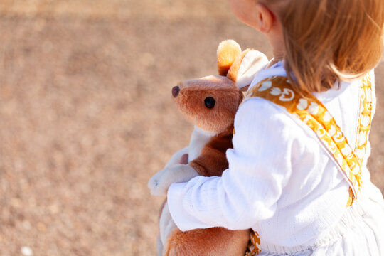 Aussie kangaroo toy held by toddler child outside