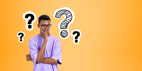 Pensive African man college student and question marks - obrazy, fototapety, plakaty