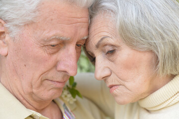 Portrait of sad senior couple in the park