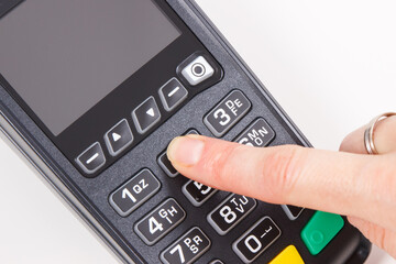 Hand of woman using credit card reader to enter PIN code. Cashless paying. Finance and banking