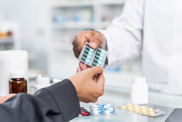 Close up hands of Handsome asian male selling pharmacist and female customer buying medicine in the...