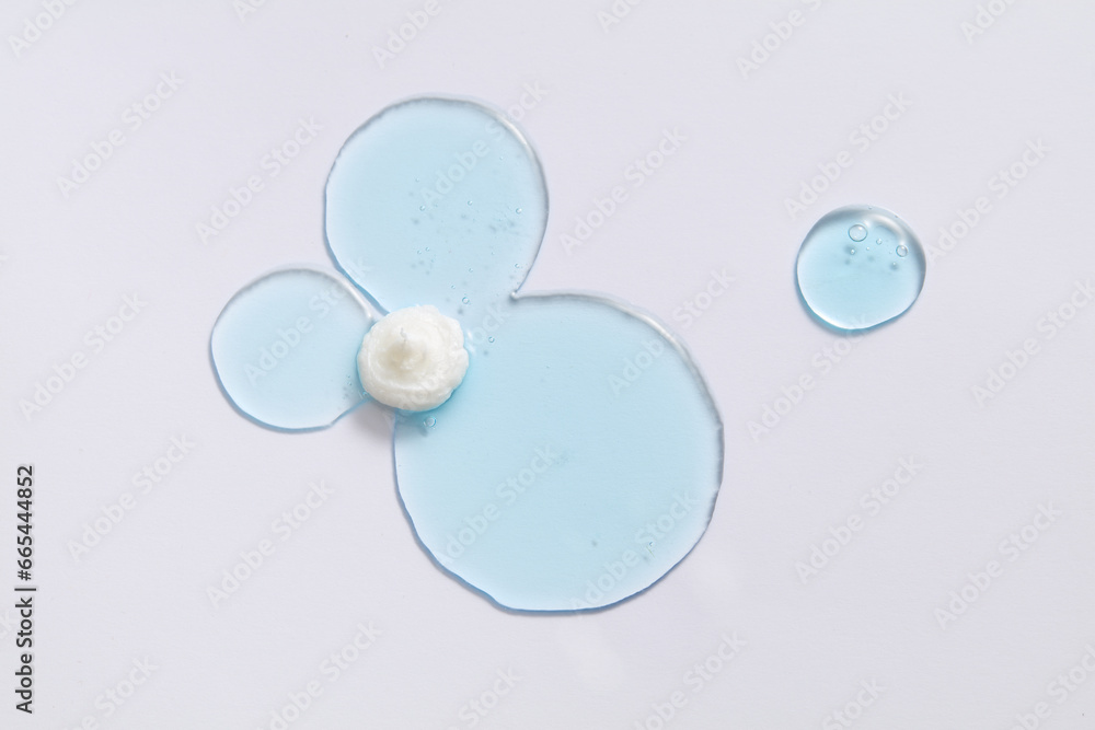 Wall mural Blue liquid gel smear on white background. Beauty cosmetic smudge such as transparent lotion, facial jelly serum, cleanser, shower gel or shampoo top view.