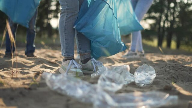 Teamwork.Cleaning plastic garbage in bag on beach in summer.Environmental pollution.Volunteer family clean up plastic waste garbage.Group of people are cleaning up waste garbage together.active people