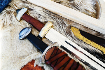 Medieval weapons located on the skin of an animal. Steel swords in leather cases and braid. Retro style. Close-up