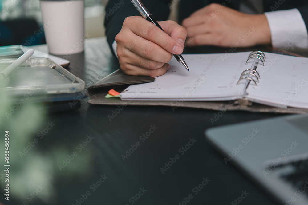 Aufkleber man hands with pen writing on notebook in the office.learning, education and work.writes goals, plan