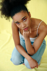 Young beautiful girl over yellow background in studio.	