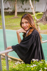 Happy graduation to a beautiful young woman smiling broadly in front of the camera.