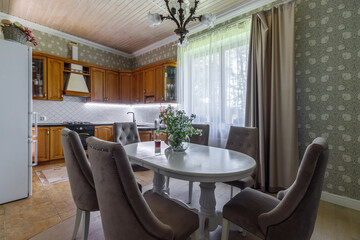 The interior of a modern light dining room with a long oval table surrounded by seats