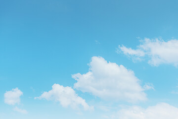 Blue sky and white clouds float in the sky on a clear day with warm sunlight. The sky was clear in the calm sunshine. Bright winter weather background.