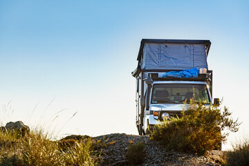 Off road vehicle with roof top tent camping on nature