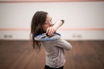 young caucasian girl raquet squash game court ball play tennis