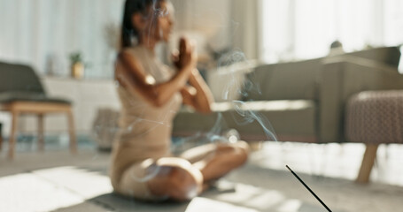 Woman, yoga and incense with lotus pose on living room floor for zen, mental health and wellness in...