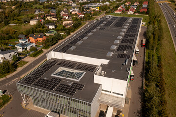 Drone photography of large logistical warehouse and office rooftop with solar energy modules