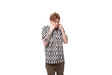 young indignant european man with golden hair is dressed in a stylish black and white shirt on a studio background with copy space