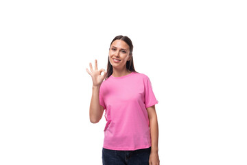 young european woman with black hair in a pink t-shirt has a proposal on a white background with copy space