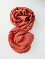 orange spirall rolled rag on white table. spirall folded in the shape. rolled fabric tissue. crumpled rag swirl