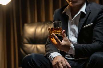 Businessman wearing a suit whiskey glass of liquor.