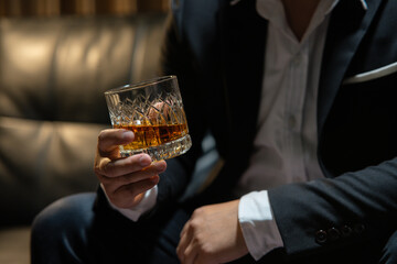 Businessman wearing a suit whiskey glass of liquor.