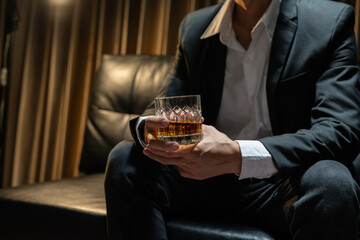 Businessman wearing a suit whiskey glass of liquor.