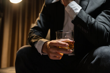 Businessman wearing a suit whiskey glass of liquor.