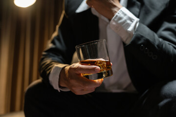 Businessman wearing a suit whiskey glass of liquor.