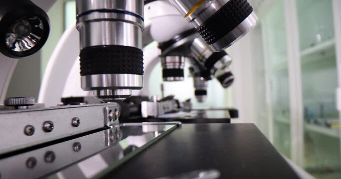 Professional microscopes with lenses in row at technology exhibition. Laboratory equipment and science