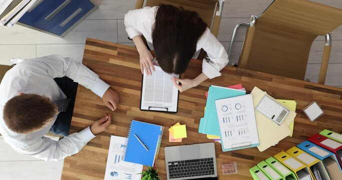 Client buys company services, signs document, accepts terms of agreement and approves terms of contract top view. Interview and signing of business contract