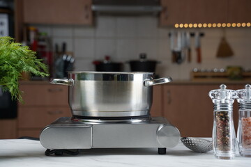Steel cooking pan without lid on electric hob with boiling water
