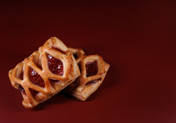 Puff pastry pastry with lingonberry jam on a dark red background. Cookies with lingonberry jam.