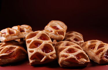 Puff pastry pastry with lingonberry jam on a dark red background. Cookies with lingonberry jam.
