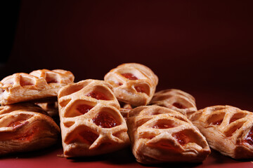 Puff pastry pastry with lingonberry jam on a dark red background. Cookies with lingonberry jam.