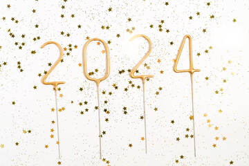 golden numbers 2024 and sequins in the form of stars with glitter on a white isolated background....