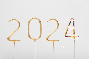 Burning golden numbers 2024 in the form of sparklers on a gray isolated background. The concept of...