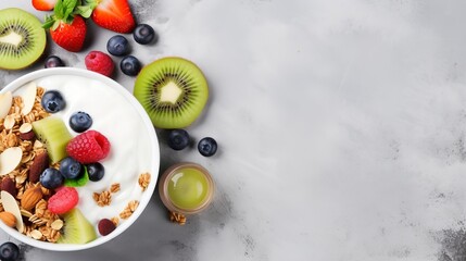 A top-down view of a delectable homemade granola dish filled with a variety of nuts and raisins, along with fresh kiwi, blueberries, banana, strawberries, and a dollop of plain yogurt