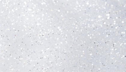 White texture scattered with small silver glitter particles of varying sizes and shapes.