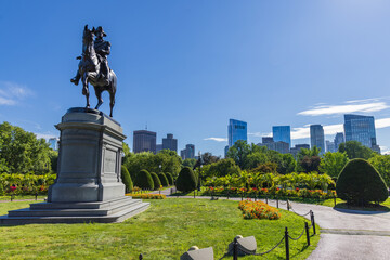 George Washington statue in the Boston Common park with high-rise buildings in the background,...