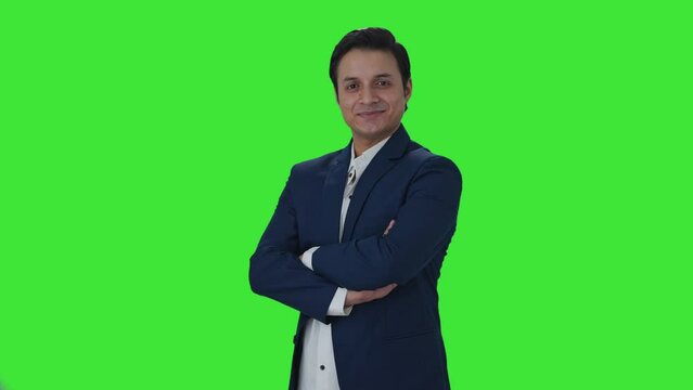 Portrait of Happy Indian journalist standing crossed hands Green screen