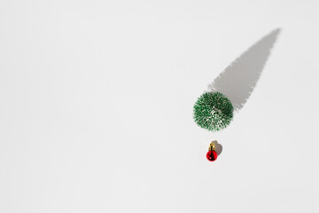 Cristmas tree and red decoration ball isolated on white background with copy space. Minimal holiday concept.