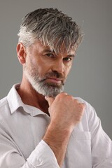Portrait of confident man with beautiful hairstyle on light grey background