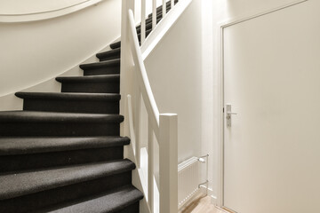 a staircase with black carpet and white trim on the stairs leading up to the second floor in an apartment building