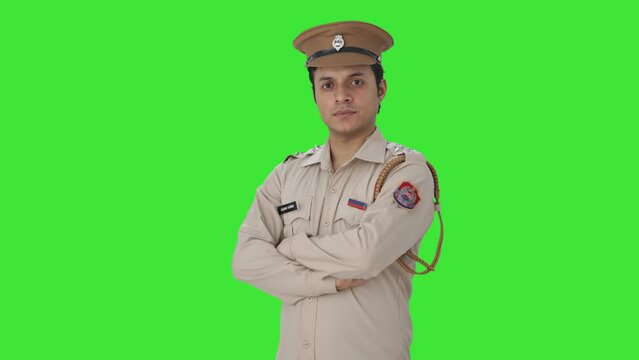 Portrait of Confident Indian police officer standing crossed hands Green screen
