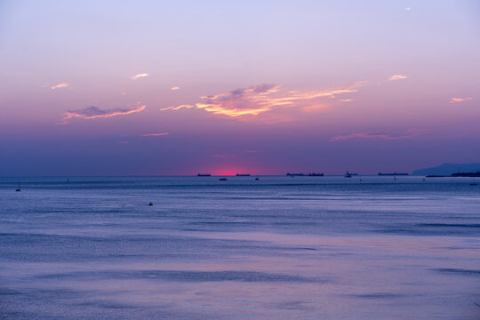 Amazing beach sunset with endless horizon and ships figures in the distance. High quality photo