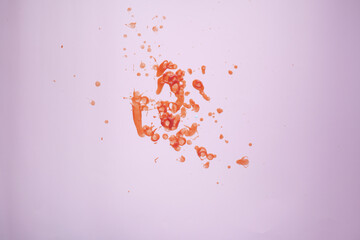 red ketchup splashes on purple background, tomato puree texture.